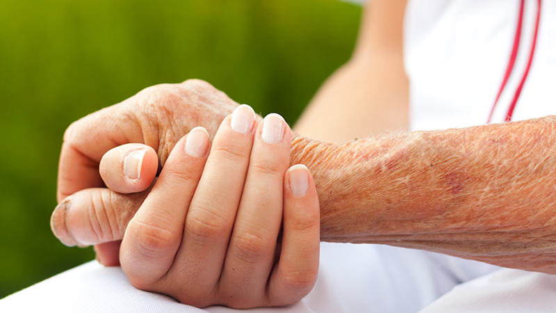 Duas pessoas dão as mãos para decidir sobre o testamento vital